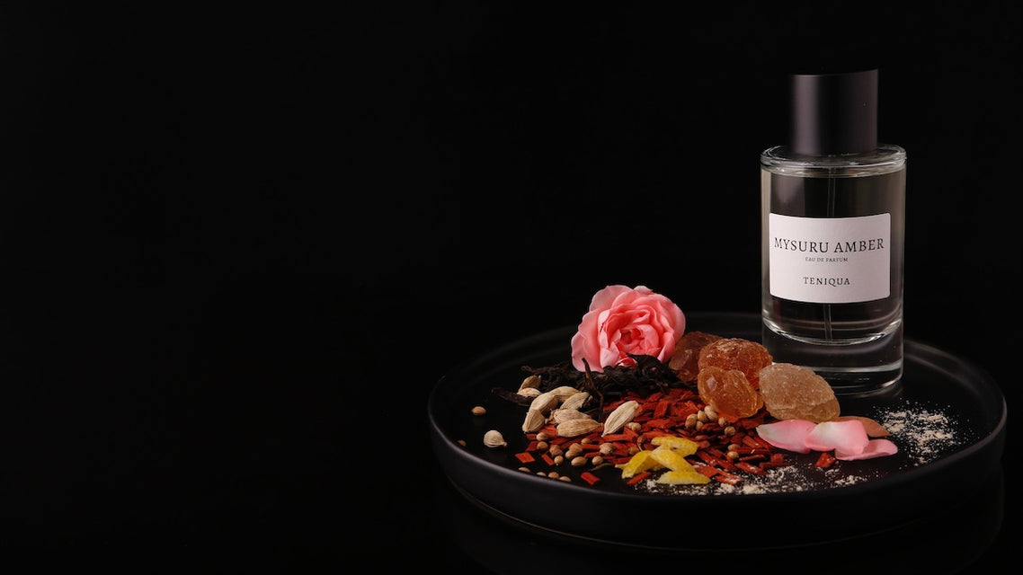 Bottle of Mysuru Amber edp plate with ingredients highlighted against black background